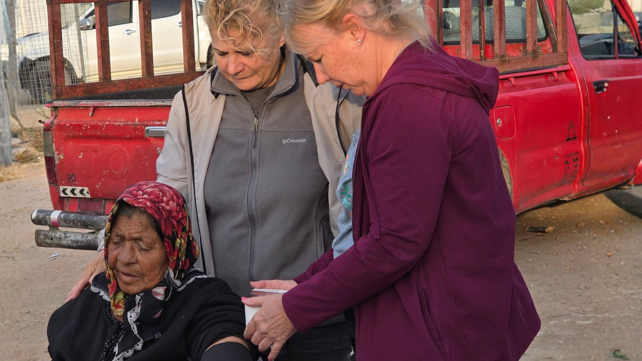 Christian mission volunteers serving a local woman during an affordable international outreach trip.