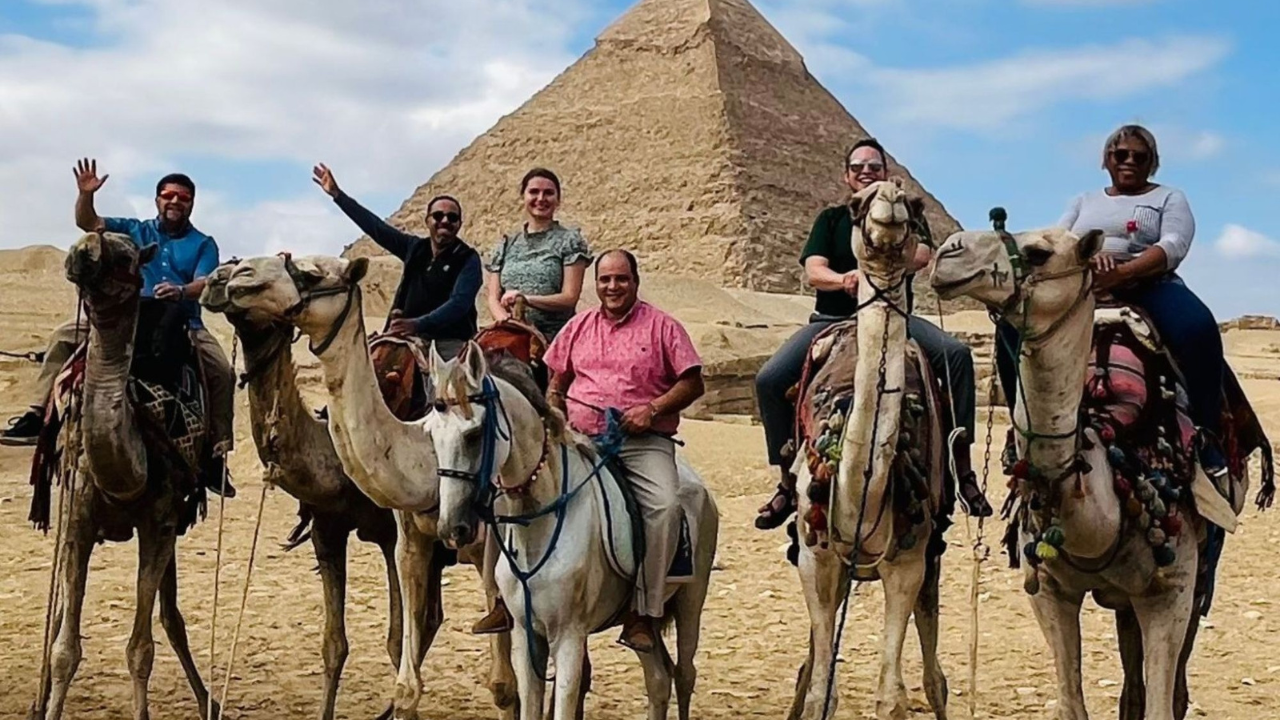 Christian mission trip team riding camels near the pyramids during an international ministry journey.