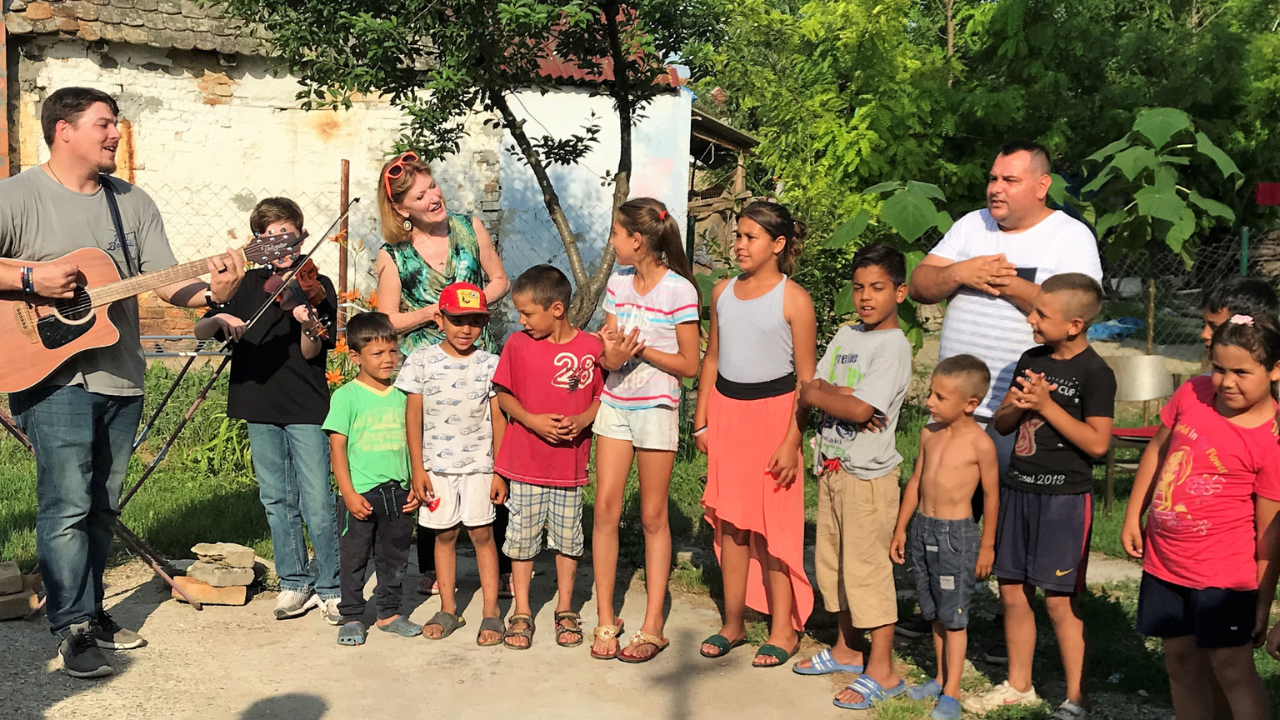 Christian mission team leading worship with children during an international outreach trip.