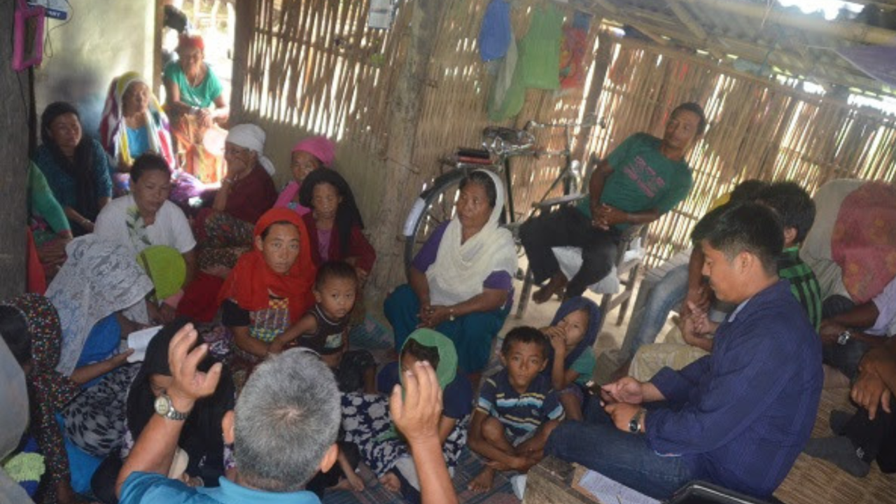 Mission team meeting with local families inside a rural bamboo home.
