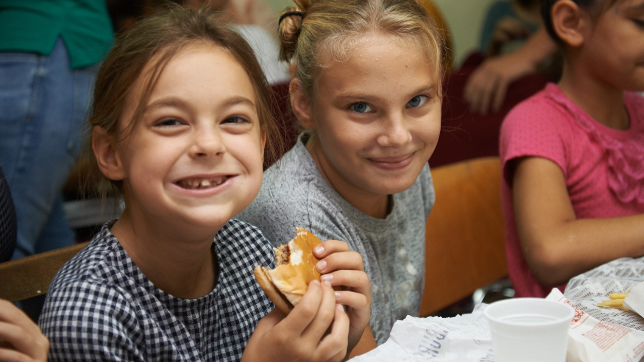 Children sharing a meal during a mission organization’s community outreach.