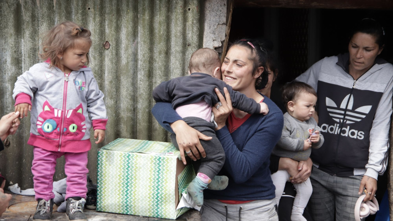 Mothers and young children gathered outside their home during mission outreach.