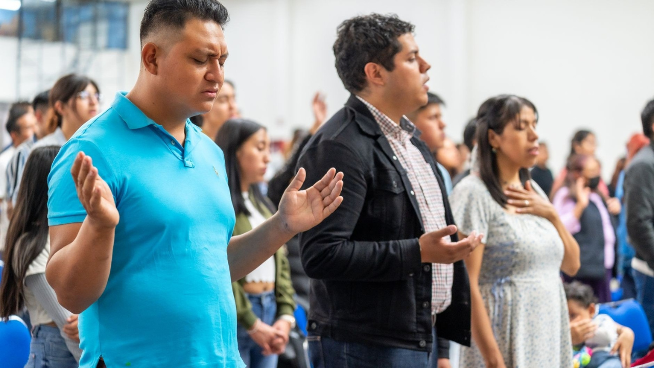 Christian mission team members praying together during a worship gathering.